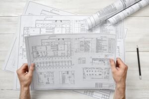 mani che disegnano un progetto di costruzione